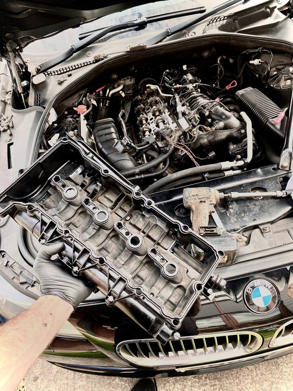 Mechanical repair with the engine valve cover removed from a BMW